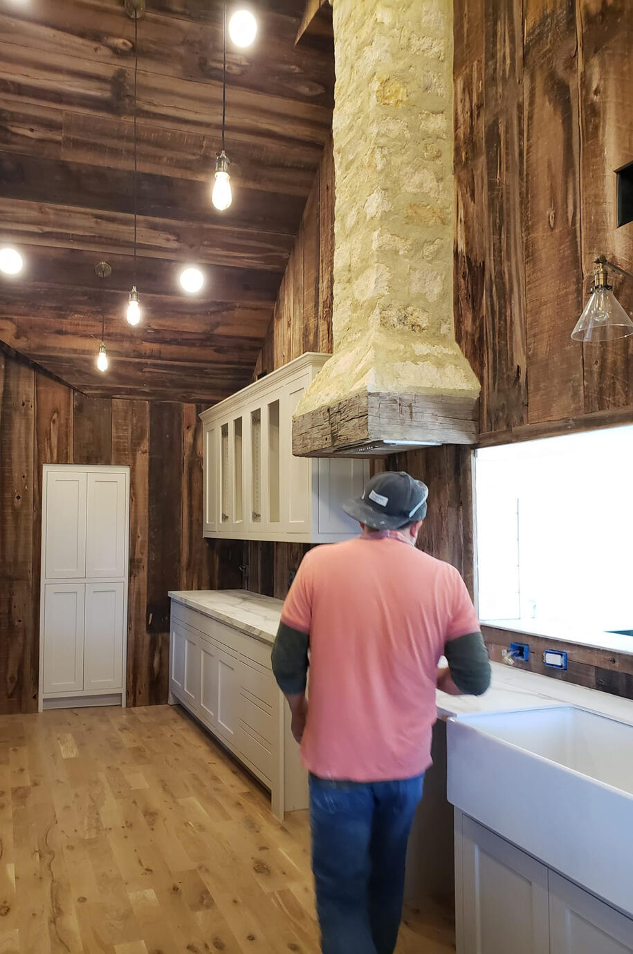 B. Master himself in a rustic, wood and stone kitchen, with white granite counters and a stone ventilation shaft